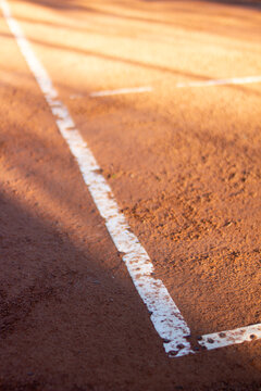 track and field or tennis clay field. detail with copy space and light and shadow.