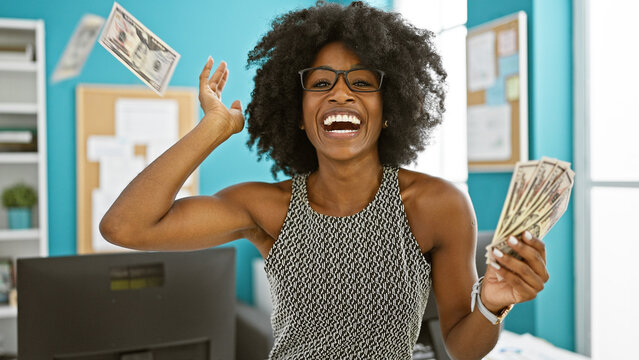 African american woman business woman throwing dollars smiling at the office
