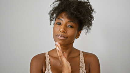 African american woman wearing lingerie touching face over isolated white background
