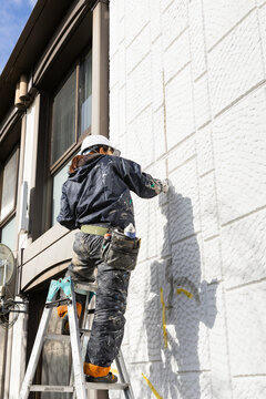 建築現場女子　外壁のクラック補修工事　塗装