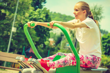 Obraz premium Girl doing legs exercise at outdoor gym area