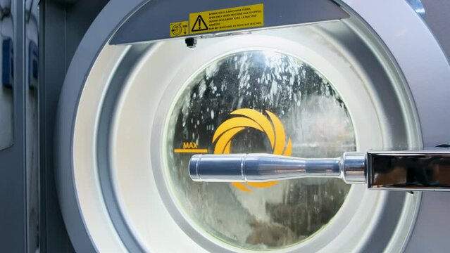 Rinsing washing machine drum with water. Professional dry cleaning of clothes
