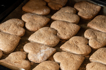 Fototapeta na wymiar Homemade Valentine's Day heart shaped cookies. View from above. Heart-shaped gingerbread cookies on baking sheet. Toned.