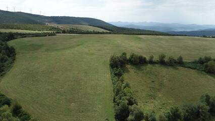 Vista aérea general de un campo con la carretera y montañas al fondo.