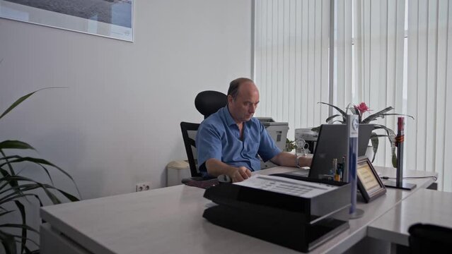 Mature senior sales manager works on a laptop