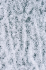 Background, texture of oilcloth, tarpaulin covered with white snow on the surface. Photo, top view.