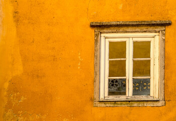 White old window on a yellow wall of the National Palace of Pena in Sintra, Portugal