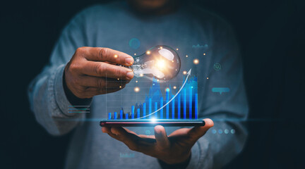 Financial innovation technology. Businessman holding light bulb and analysis growing of business...