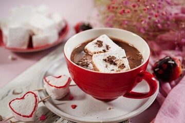 Valentines day hot chocolate or cocoa with homemade heart marshmallows on pink background