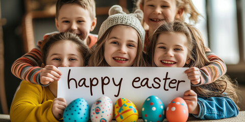 Joyful group of children holding a 'Happy Easter' sign with colorful eggs in the foreground