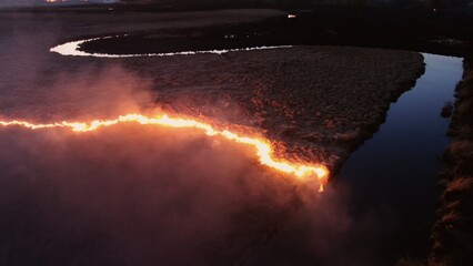 Aerial Nighttime View of Fire Encroaching on Waterway