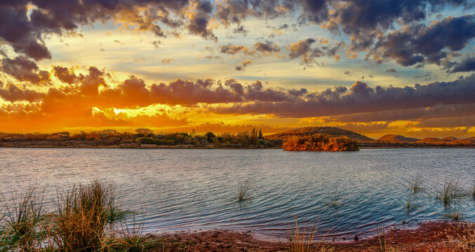 gaborone dam in botswana at sunset, southern africa typical landscape with hills