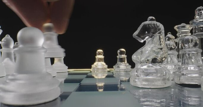 Hands moving chess piece on chess board game, macro probe lens shot, concept of success, business, leadership
