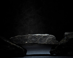 granite stones for the podium. black natural stones with texture on a dark background for a minimalist podium for the presentation of a product: cosmetics, medicine, perfumery, body care, jewelry