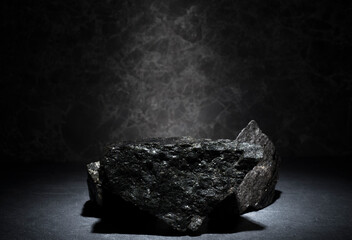 granite stones for the podium. black natural stones with texture on a dark background for a minimalist podium for the presentation of a product: cosmetics, medicine, perfumery, body care, jewelry