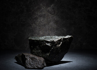 granite stones for the podium. black natural stones with texture on a dark background for a...