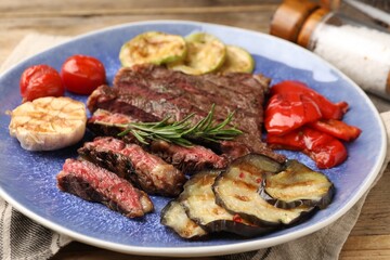 Delicious grilled beef with vegetables and rosemary on table, closeup