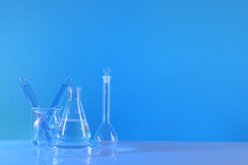 Laboratory analysis. Different glassware on table against light blue background