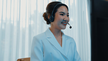 Businesswoman wearing vivancy headset working in office to support remote customer or colleague. Call center, telemarketing, customer support agent provide service on telephone video conference call
