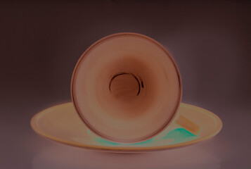 Modern minimalist empty cup & saucer with bottom circle of an empty cup rests on its side. Shapes...