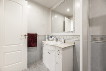 Fototapeta na wymiar Bathroom with white furniture, square shower cabin, white toilets, white access door, stoneware floors