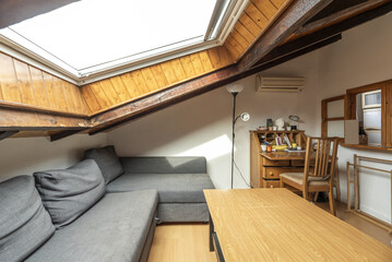 Living room in a house with sloping ceilings and a large skylight