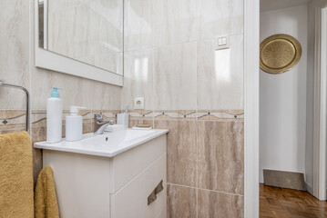 A bathroom with a white resin sink under a frameless mirror