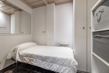 A small bedroom with white walls with wooden coffered ceiling, a single bed