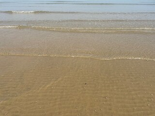 View of a sandy beach during the day with a blue sky background. clear sea water. vintage color beach
