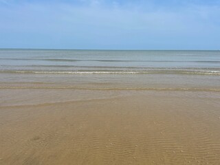 View of a sandy beach during the day with a blue sky background. clear sea water. vintage color beach
