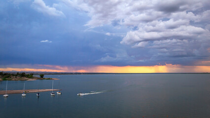 
We see a beautiful sunset, sailboats parked in the waters of the lake, in the background a cloudy...