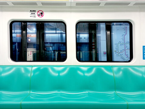 Kaohsiung, Taiwan - February 3, 2024: Kaohsiung Metro (KMRT) train interior seating area, departure station, bright train interior, empty seats. Passenger seatless train with green seats