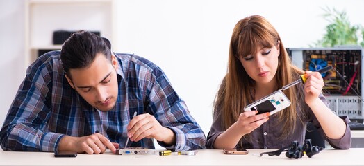 Two technicians working at computer warranty center