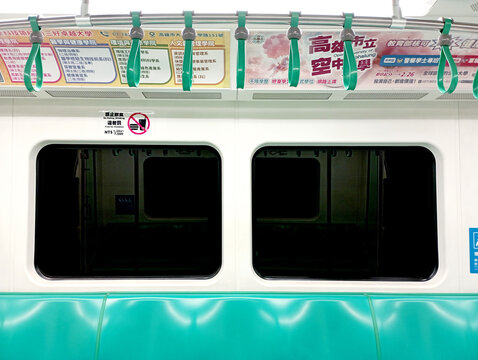 Kaohsiung, Taiwan - February 3, 2024: Kaohsiung Metro (KMRT) train interior seating area, departure station, bright train interior, empty seats. Passenger seatless train with green seats