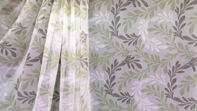 Tulle curtain is in motion. The fabric is delicate and thin airy for the window.