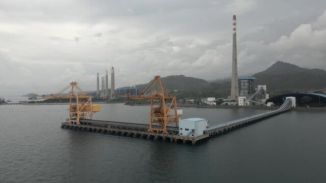 Aerial orbits coal jetty at Nusantara Coal Power Plant in Java, IDN