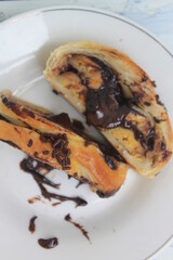 Slices of Chocolate Banana Strudel sprinkled with chocolate sprinkles in a white plate on the table