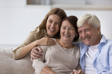 Happy senior woman enjoying warm good relationship with adult daughter and loving older husband,...