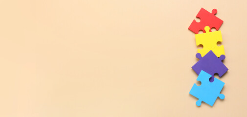 Colorful puzzle pieces on beige background with space for text. Concept of autism spectrum disorder