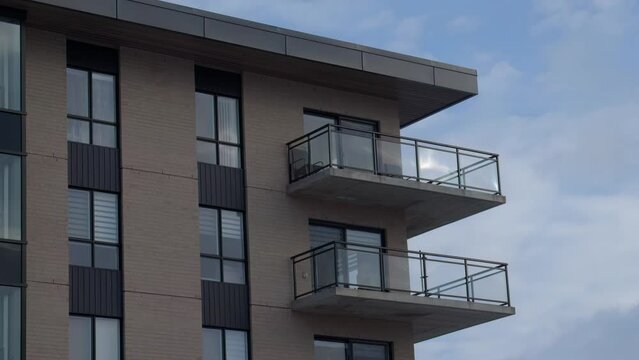 building corner time lapse residential architecture balconies urban city life on cloudy sky
