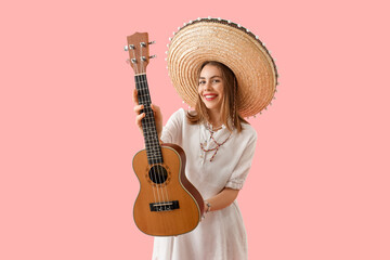 Young woman in sombrero hat with guitar on pink background. Mexico's Day of the Dead (El Dia de Muertos) celebration