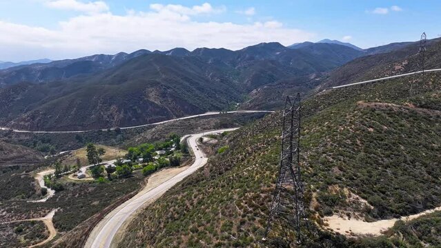 timelapse of a large 500kv electrical transmission utility structure in the hills of santa clarita california on a sunny day AERIAL TIMELAPSE TRUCKING PAN