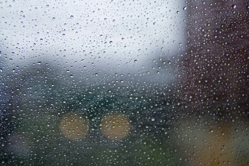 Water drop on​ glass of​ car​ on​ the​ Road​ in rainy season.