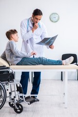 Young male doctor pediatrist and boy in wheel-chair