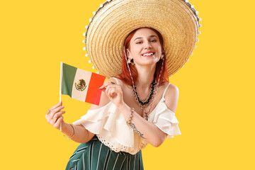 Young woman in sombrero hat with flag on yellow background. Mexico's Day of the Dead (El Dia de Muertos) celebration