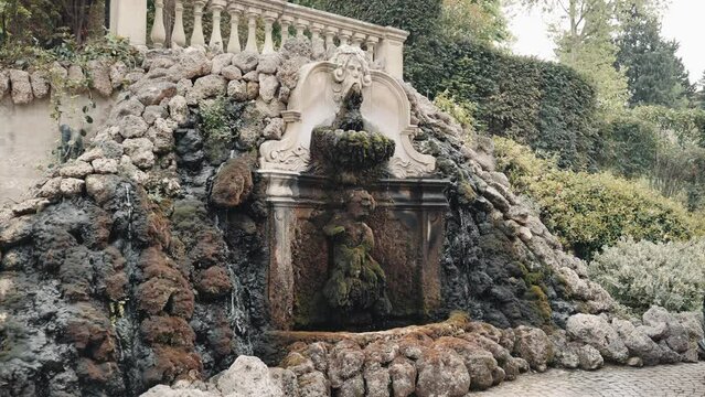 Fountain, statue and stone face at the main entrance of nobel Villa Cora in Florence tuscany italy