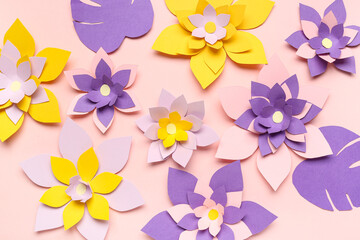 Colorful origami flowers with leaves on pink background
