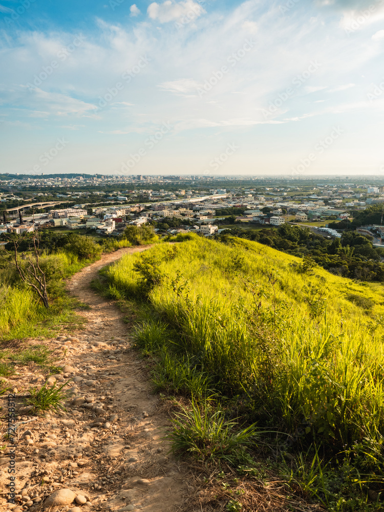 Wall mural view of city from the beautiful mountain. blue sky and green meadow.