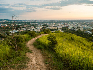 View of city from the beautiful mountain. Blue sky and green meadow.