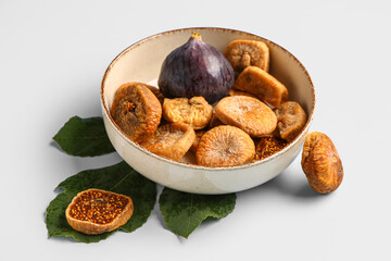 Bowl with sweet dried figs and fresh fruit on blue background